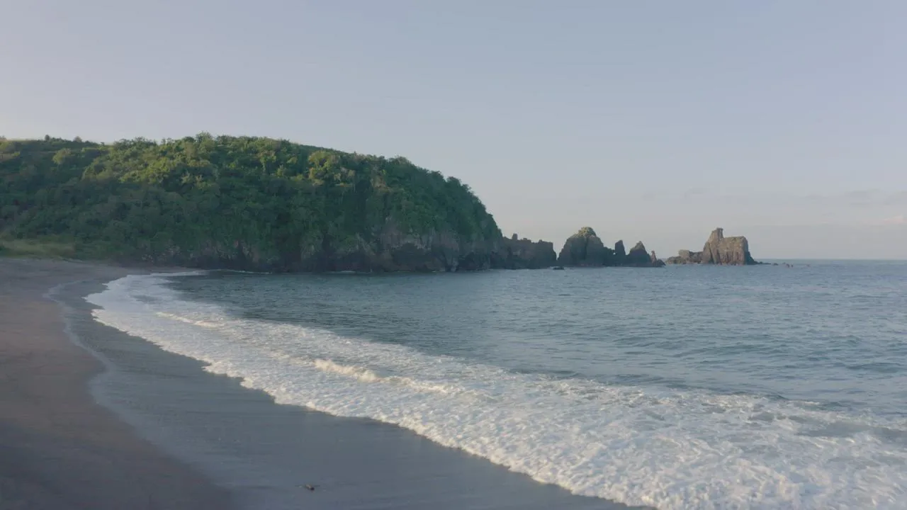 A quiet coastline and rocky sea stacks in soft morning light